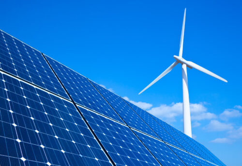 blue sky with solar panels and wind turbine