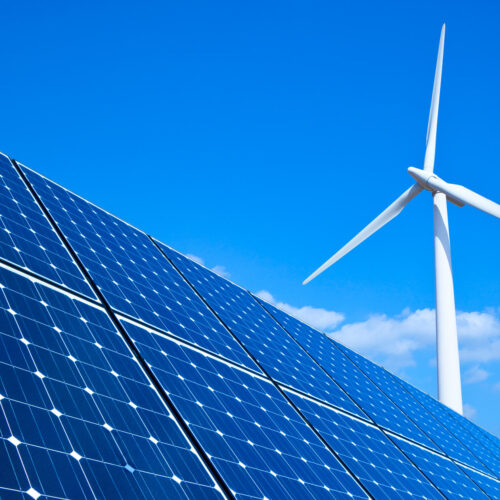 blue sky with solar panels and wind turbine