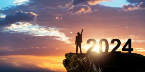 Businessman standing on the top of rock with number 2024