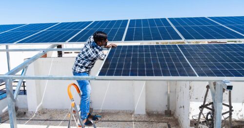 Indian worker maintaining solar panels