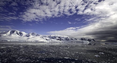 Antarctica Peninsula Landscape, sunny blue sky with dramatic clouds, icebergs drifting in the antarctic sea, see my antarctic lightbox for more