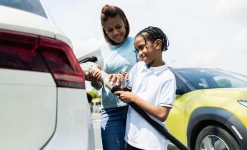mother and son plugging in electric car